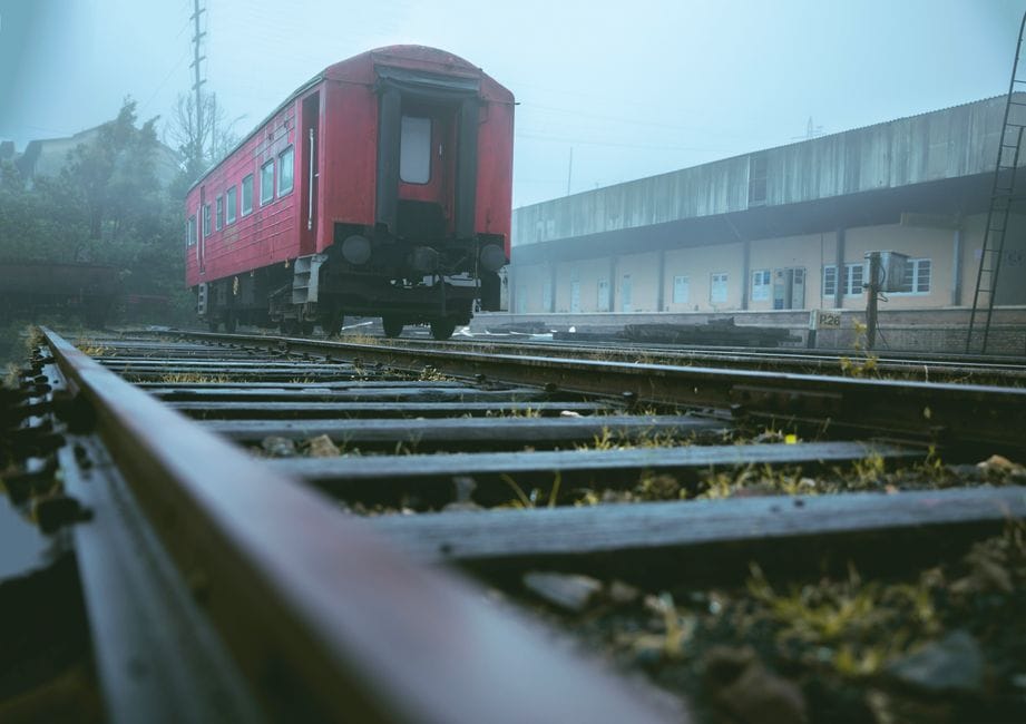 A vintage red train stands on railway tracks on a misty day in Ella, Sri Lanka.