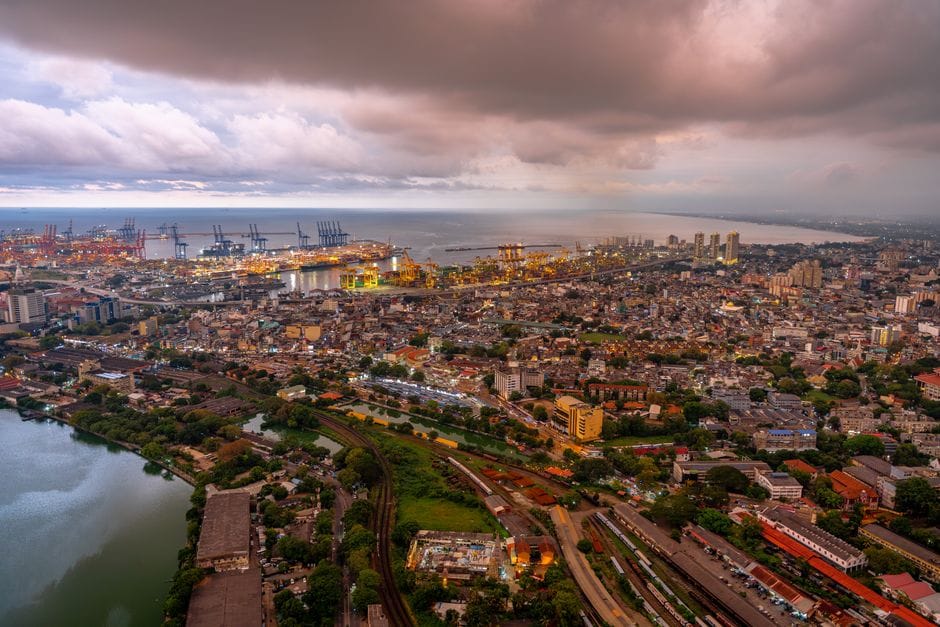 Stunning aerial view of Colombo city skyline and port during twilight, showcasing urban landscape.